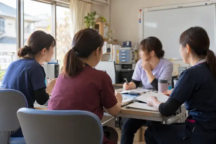 朝のミーティングで話し合う看護師たち